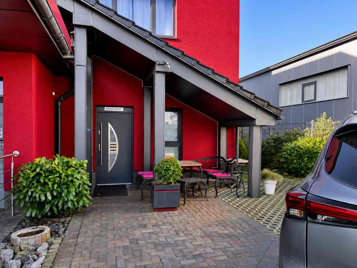 Ruhige Innenhofterrasse neben dem Hoteleingang mit Sitzplätzen und Bepflanzung